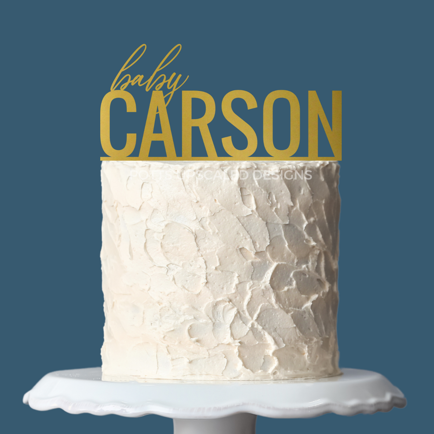 gold baby name cake topper for baby shower on a white cake