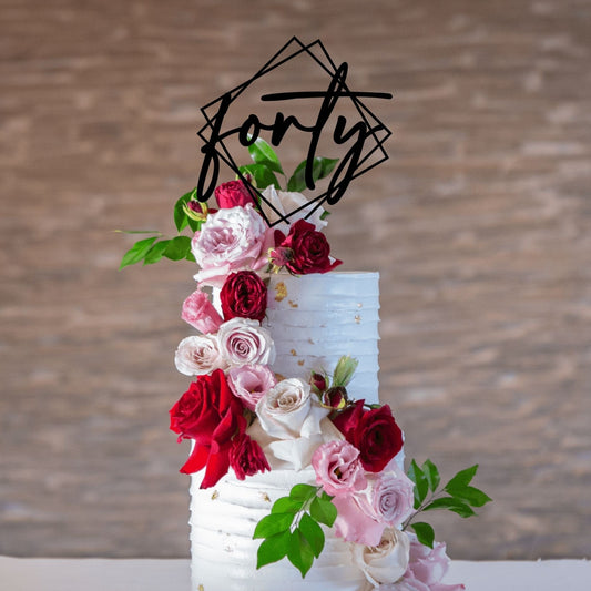 Forty Double Diamond Square cake topper in black on a tiered cake decorated with pink and red roses for a birthday party