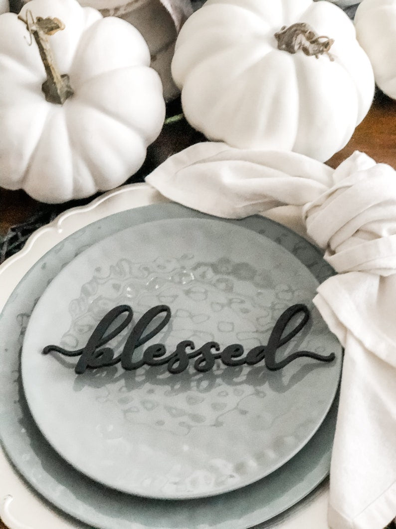 black blessed place card on a thanksgiving place setting teal plates and white pumpkins