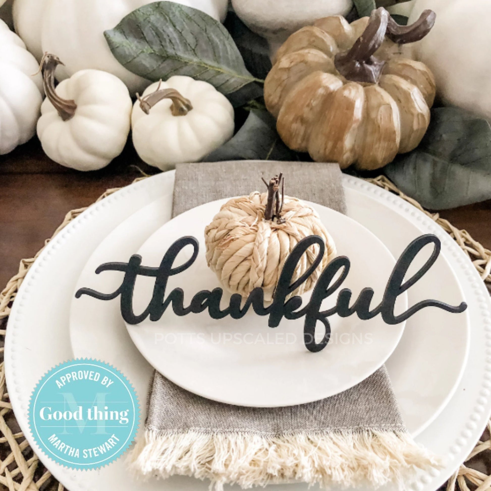 black wood thankful place card on white plates with pumpkin centerpiece decorating a thanksgiving table for fall