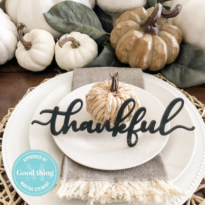black wood thankful place card on white plates with pumpkin centerpiece decorating a thanksgiving table for fall